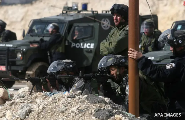 Israeli soldiers take position during clashes with Palestinian stone throwers in the West Bank neighbourhood of Al-Ram, adjacent to Israeli-annexed east Jerusalem, on February 25, 2012. At least nine Palestinians were in...