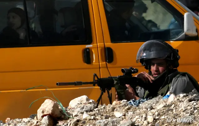 Israeli soldiers take position during clashes with Palestinian stone throwers in the West Bank neighbourhood of Al-Ram, adjacent to Israeli-annexed east Jerusalem, on February 25, 2012. At least nine Palestinians were in...