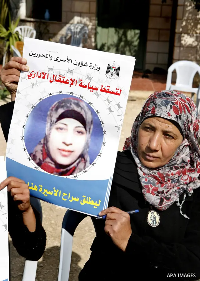 Relatives of Palestinian detainee, Hana Shalabi, holds placards depicting Shalabi, in the West Bank village of Birqin, near Jenin February 27, 2012. Shalabi, released by Israel in a prisoner swap last year but re-arreste...