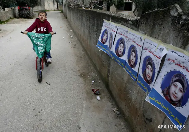 Relatives of Palestinian detainee, Hana Shalabi, stick up placards depicting Shalabi, in the West Bank village of Birqin, near Jenin February 27, 2012. Shalabi, released by Israel in a prisoner swap last year but re-arre...