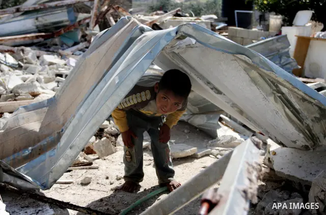 Palestinian Children inspects their hous which was demolished by Israeli army that was built without a construction permit, in bedouin area, village of Jaba, north of Jerusalem on Feb. 27, 2012. Photo by Issam Rimawi