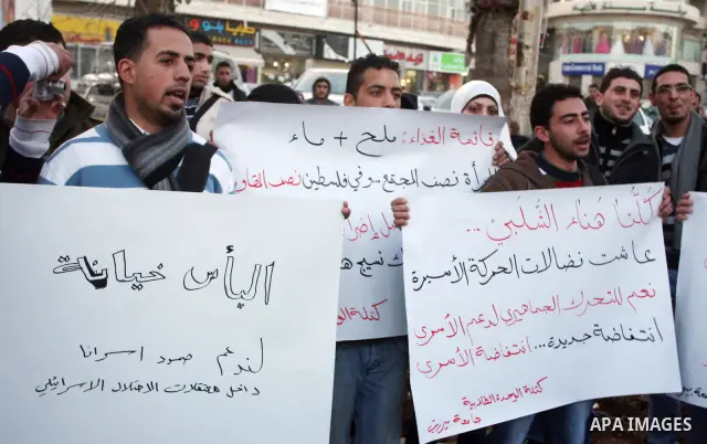 Palestinians hold up banners for Hana Al-Shalabi, a Palestinian prisoner on hunger strike jailed in Israel, as they protest against Israel's policy of administrative detention, in the West Bank city of Ramallah , Monday,...