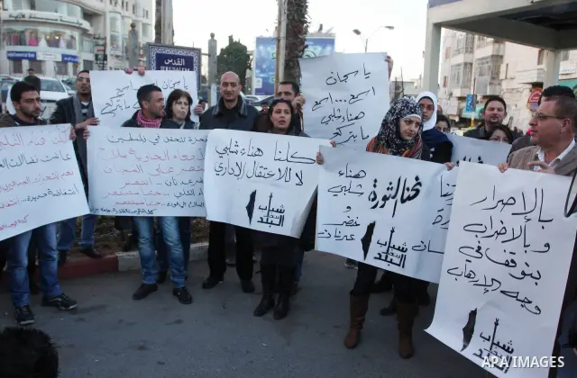 Palestinians hold up banners for Hana Al-Shalabi, a Palestinian prisoner on hunger strike jailed in Israel, as they protest against Israel's policy of administrative detention, in the West Bank city of Ramallah , Monday,...