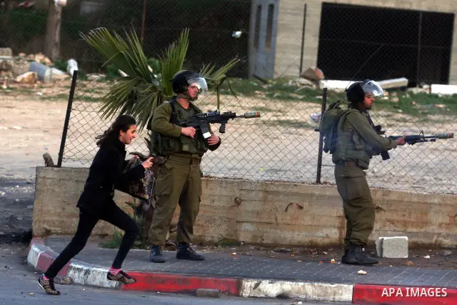 An Israeli soldier fires tear gas during clashes with stone-throwing Palestinians in the West Bank district of al-Ram, bordering Israel and annexed East Jerusalem, on February 28, 2012. Photo by Issam Rimawi
