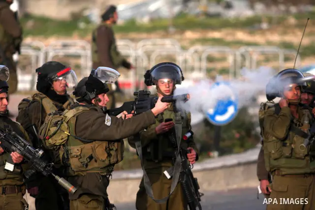 An Israeli soldier fires tear gas during clashes with stone-throwing Palestinians in the West Bank district of al-Ram, bordering Israel and annexed East Jerusalem, on February 28, 2012. Photo by Issam Rimawi