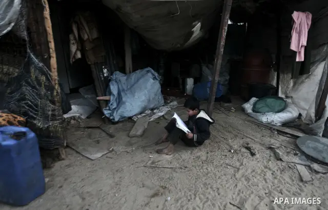 A Palestinian child is doing home work inside his family tent in one of the most poor regions in Al-Nusirat neighborhood, central Gaza Strip on 28 February 2012. The United Nations Relief and Works Agency for Palestine R...
