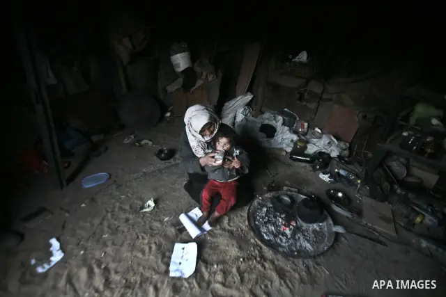 A Palestinian mother eating her child at their house inbetween makeshift tents in one of the most poor regions in Al-Nusirat neighborhood, central Gaza Strip on 28 February 2012. The United Nations Relief and Works Agenc...