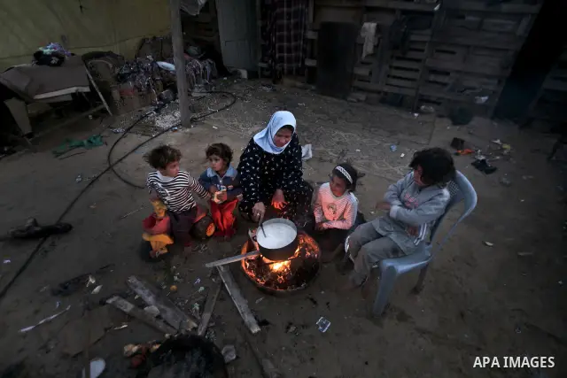 A Palestinian mother cooks on firewood at their house inbetween makeshift tents in one of the most poor regions in Al-Nusirat neighborhood, central Gaza Strip on 28 February 2012. The United Nations Relief and Works Agen...