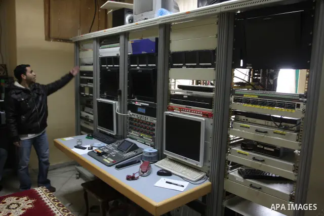 Staff members of a local private television station "Watan", look at the damage caused after Israeli troops raided this and another Palestinian television station in the West Bank city of Ramallah overnight, seizing comp...