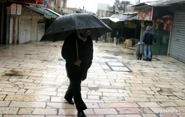 Palestinians walk in a street during the heavy rain and cold winds in Jerusalem's Old City, on Mar. 01, 2012. Photo by Mahfouz Abu Turk