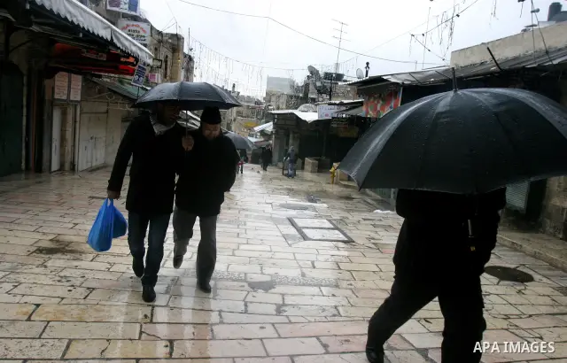 Palestinians walk in a street during the heavy rain and cold winds in Jerusalem's Old City, on Mar. 01, 2012. Photo by Mahfouz Abu Turk