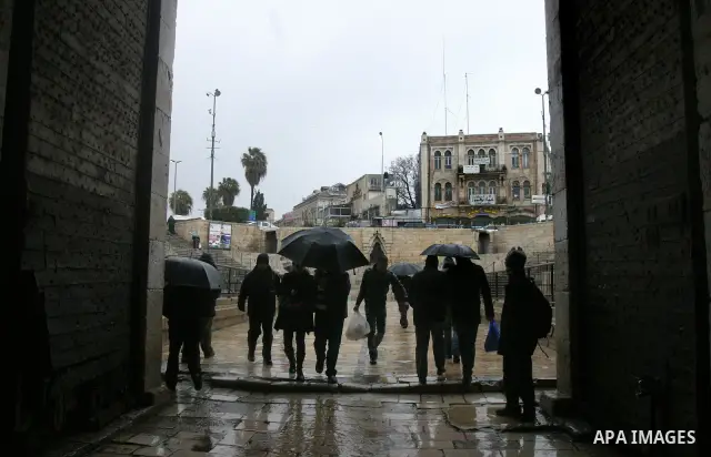 Palestinians walk in a street during the heavy rain and cold winds in Jerusalem's Old City, on Mar. 01, 2012. Photo by Mahfouz Abu Turk