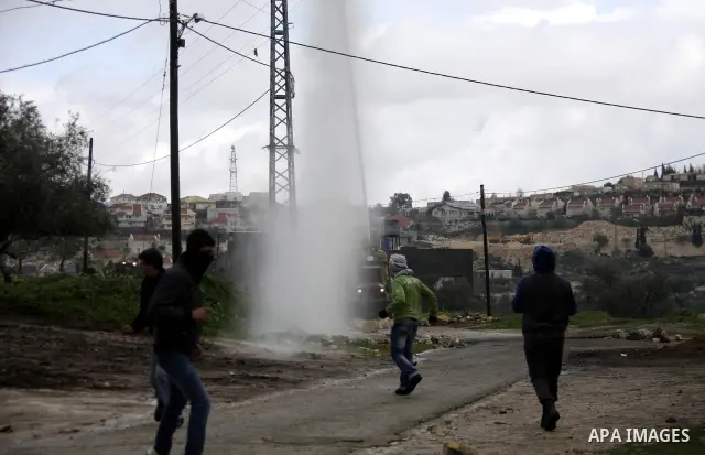 Palestinian protesters run away from tear gas canisters fired by Israeli soldiers during a demonstration against the expropriation of Palestinian land by Israel in the village of Kfar Qaddum, near the West Bank city of N...