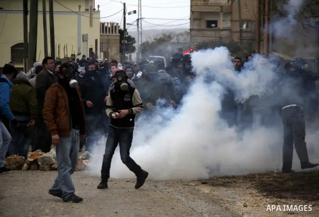Palestinian protesters run away from tear gas canisters fired by Israeli soldiers during a demonstration against the expropriation of Palestinian land by Israel in the village of Kfar Qaddum, near the West Bank city of N...