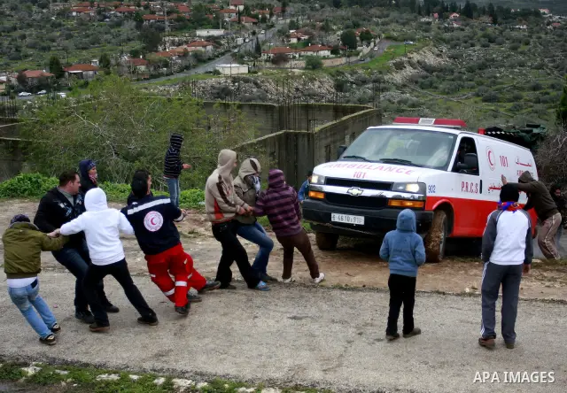 Palestinian protesters pull an ambulance during a demonstration against the expropriation of Palestinian land by Israel in the village of Kfar Qaddum, near the West Bank city of Nablus, on March 2, 2012. Photo by Wagdi E...