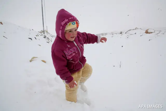 Palestinian girls play with snow in the West Bank city of Hebron as wintry weather swept through the region on March 2, 2012. Photo by Mamoun Wazwaz