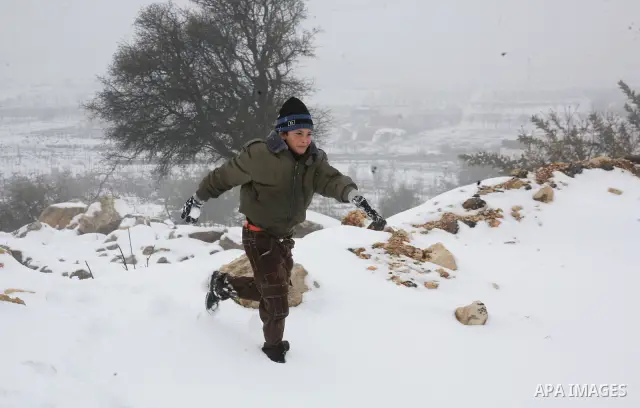 Palestinians walks during a snow storm in the West Bank city of Hebron as wintry weather swept through the region on March 2, 2012. Photo by Mamoun Wazwaz