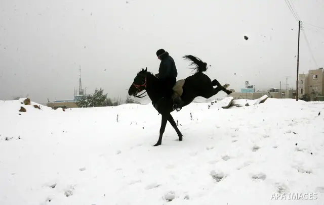 Palestinians play with snow in the West Bank city of Hebron as wintry weather swept through the region on March 2, 2012.Photo by Mamoun Wazwaz