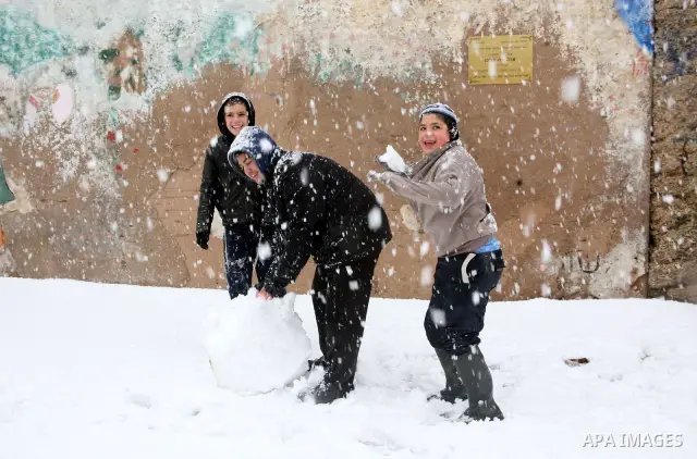 Jewish youths throw snowballs as they play next to Israeli army position in the West Bank city of Hebron as wintry weather swept through the region on March 2, 2012. Photo by Mamoun Wazwaz