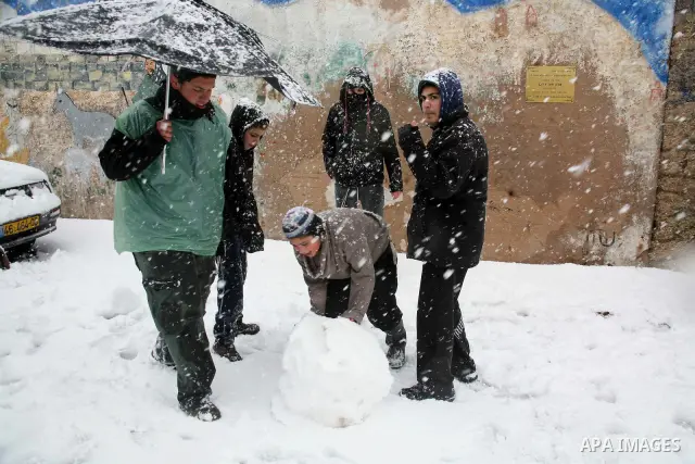 Jewish youths throw snowballs as they play next to Israeli army position in the West Bank city of Hebron as wintry weather swept through the region on March 2, 2012. Photo by Mamoun Wazwaz