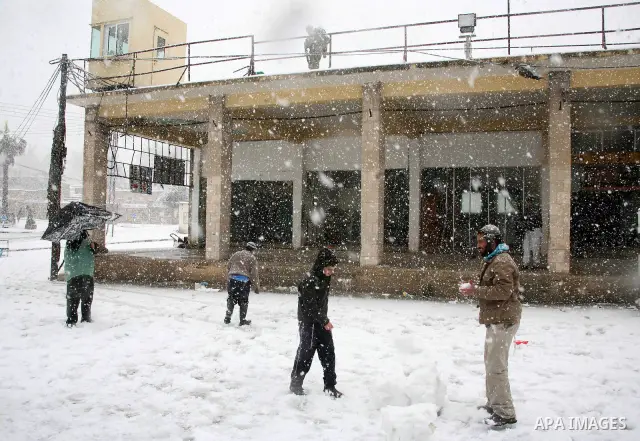 Jewish youths throw snowballs as they play next to Israeli army position in the West Bank city of Hebron as wintry weather swept through the region on March 2, 2012. Photo by Mamoun Wazwaz