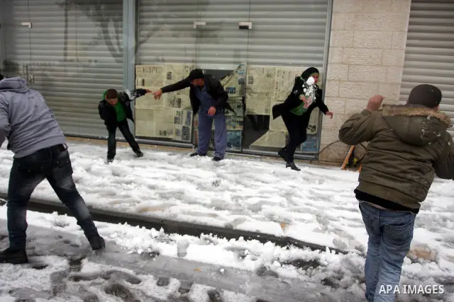 Palestinians throw snowballs in the West Bank city of Ramallah as wintry weather swept through the region on March 2, 2012. Photo by Issam Rimawi