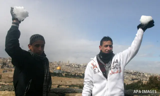 Palestinian youths play with snow in Jerusalem March 2, 2012. Snow fell in Jerusalem on Friday morning. Local media reported this was the first time in four years that snow had fell in Jerusalem causing schools to close...