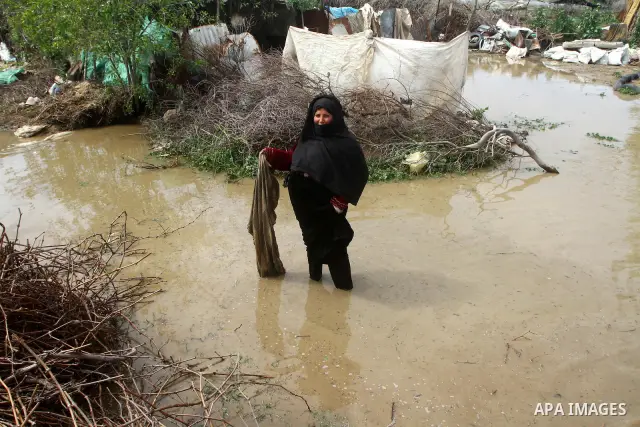 Palestinian Bedouin woman walk through muddy waters after heavy rains which flooded the Al Moghraka area in the central Gaza Strip, 04 March 2012. Photo by Ashraf Amra