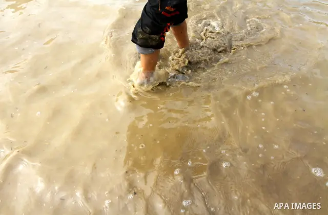Palestinian Bedouin children walk through muddy waters after heavy rains which flooded the Al Moghraka area in the central Gaza Strip, 04 March 2012. Photo by Ashraf Amra