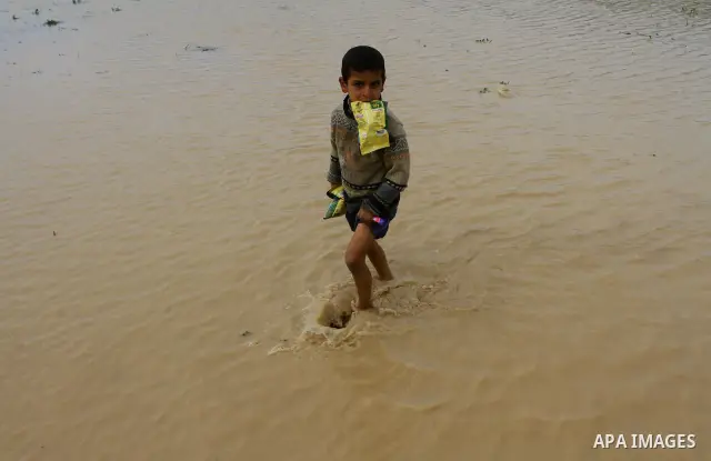 Palestinian Bedouin children walk through muddy waters after heavy rains which flooded the Al Moghraka area in the central Gaza Strip, 04 March 2012. Photo by Ashraf Amra