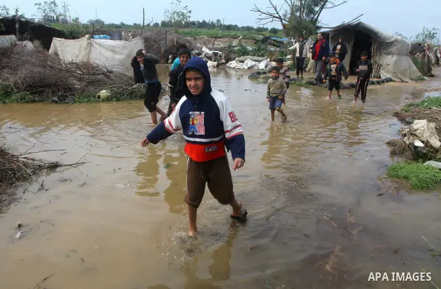 Palestinian Bedouin children walk through muddy waters after heavy rains which flooded the Al Moghraka area in the central Gaza Strip, 04 March 2012. Photo by Ashraf Amra