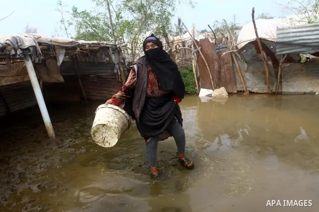 Palestinian Bedouin woman walk through muddy waters after heavy rains which flooded the Al Moghraka area in the central Gaza Strip, 04 March 2012. Photo by Ashraf Amra