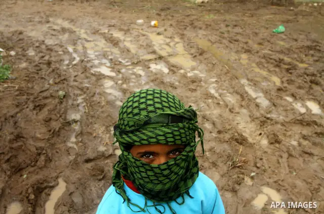 Palestinian Bedouin children walk through muddy waters after heavy rains which flooded the Al Moghraka area in the central Gaza Strip, 04 March 2012. Photo by Ashraf Amra