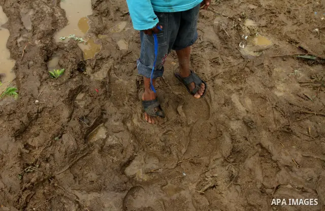 Palestinian Bedouin children walk through muddy waters after heavy rains which flooded the Al Moghraka area in the central Gaza Strip, 04 March 2012. Photo by Ashraf Amra