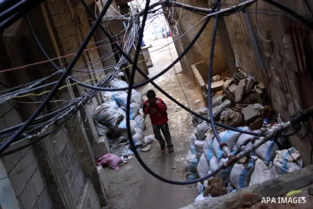 Palestinians walk in alley in one of the most poor regions at Sabra and Shatila Palestinian refugee camp in Beirut, in Lebanon, March 5, 2012. About 11,000 person live in this poor refugee camp who face hard and difficul...