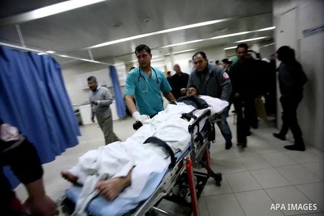 Palestinian paramedic examines a youth injured in an explosion, in the emergency room of a hospital in the West Bank city of Hebron March 6, 2012. Two Palestinian children were killed and three teenagers were injured whe...