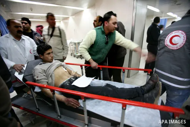 Palestinian paramedic examines a youth injured in an explosion, in the emergency room of a hospital in the West Bank city of Hebron March 6, 2012. Two Palestinian children were killed and three teenagers were injured whe...