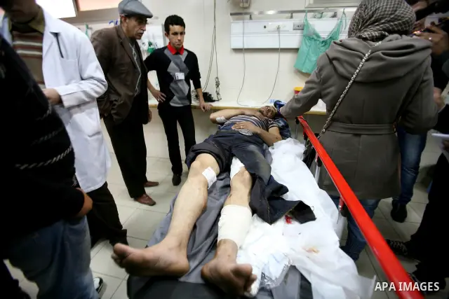 Palestinian paramedic examines a youth injured in an explosion, in the emergency room of a hospital in the West Bank city of Hebron March 6, 2012. Two Palestinian children were killed and three teenagers were injured whe...