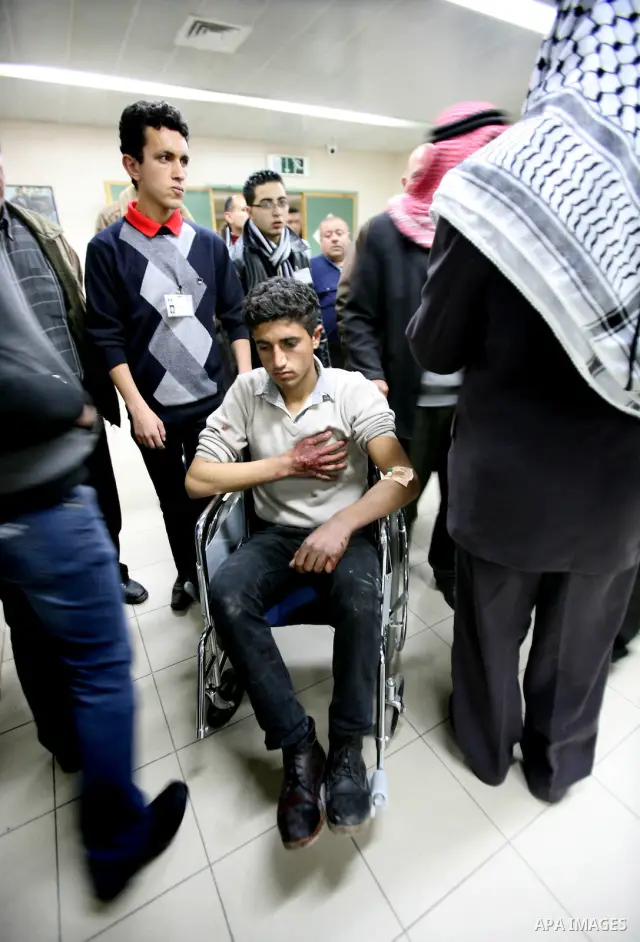 Palestinian paramedic examines a youth injured in an explosion, in the emergency room of a hospital in the West Bank city of Hebron March 6, 2012. Two Palestinian children were killed and three teenagers were injured whe...