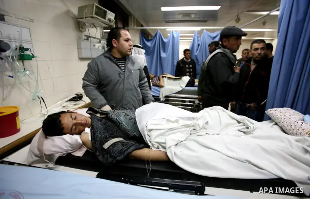 Palestinian paramedic examines a youth injured in an explosion, in the emergency room of a hospital in the West Bank city of Hebron March 6, 2012. Two Palestinian children were killed and three teenagers were injured whe...
