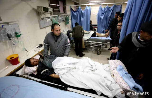 Palestinian paramedic examines a youth injured in an explosion, in the emergency room of a hospital in the West Bank city of Hebron March 6, 2012. Two Palestinian children were killed and three teenagers were injured whe...