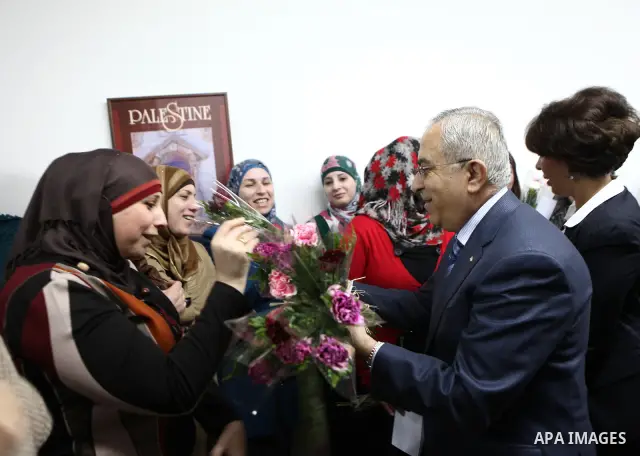 Palestinian Prime Minister, Salam Fayyad, honors women work in the Ministry of Housing and Public Works during a celebration organized on the occasion of Women's Day in the West Bank city of Ramallah, on Mar. 07, 2012. P...