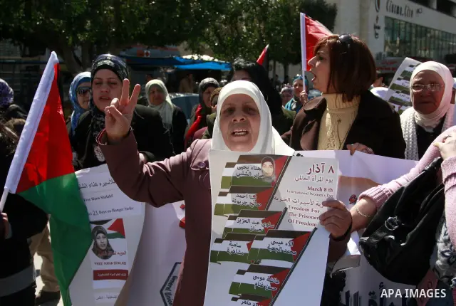 Palestinian women carry banners as they mark International Women's Day in solidarity with Hana Shalabi, a Palestinian prisoner jailed in Israel and who has been on hunger strike for 22 days, in the West Bank in Nablus, T...
