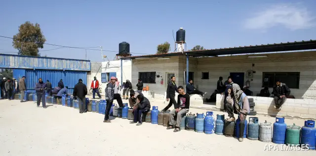 Palestinians wait to fill gas cylinders at a gas filling station in Khan Younis in the southern Gaza Strip March 8, 2012. Photo by Abed Rahim Khatib