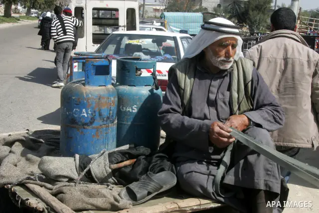 Palestinians wait to fill gas cylinders at a gas filling station in Khan Younis in the southern Gaza Strip March 8, 2012. Photo by Abed Rahim Khatib