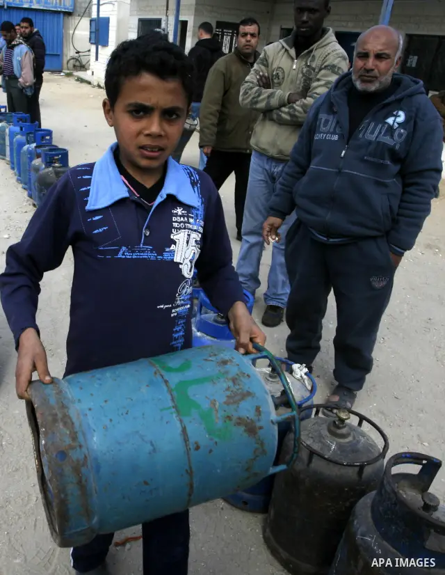 Palestinians wait to fill gas cylinders at a gas filling station in Khan Younis in the southern Gaza Strip March 8, 2012. Photo by Abed Rahim Khatib