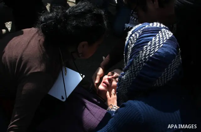 A Palestinian woman is being helped next to the checkpoint of Kalandia, West Bank, 08 March 2012, North of Jerusalem, victim of the clashes between protesters and Israely soldiers during a rally to mark the International...