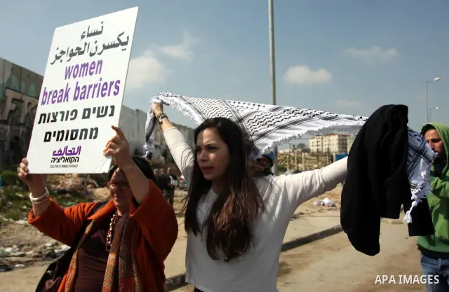 Palestinian woman shout slogans at Israeli soldiers while taking part in a demonstration to remove barriers on Palestinian land, to mark International Women's Day, on March 8, 2012, in the West Bank town of Qalandia. Pho...