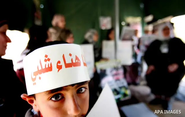 Palestinians hold portraits of jailed compatriots as they join a protest in solidarity with Hana Shalabi, a female Palestinian prisoner jailed in Israel who has been on hunger strike for 19 days, in the West Bank city of...