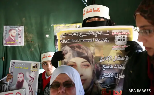 Palestinians hold portraits of jailed compatriots as they join a protest in solidarity with Hana Shalabi, a female Palestinian prisoner jailed in Israel who has been on hunger strike for 19 days, in the West Bank city of...
